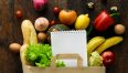 Paper bag of different health food and notebook on wooden background. Top view. Flat lay